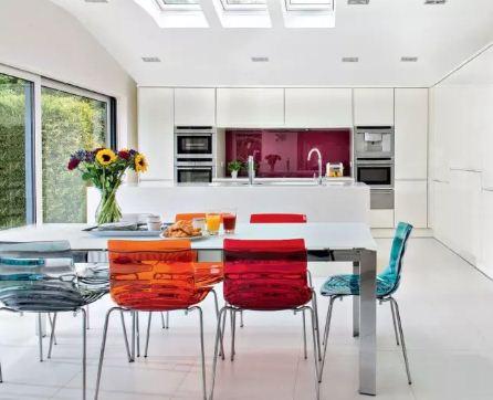 Белый стол и цветные стулья в интерьере кухни 