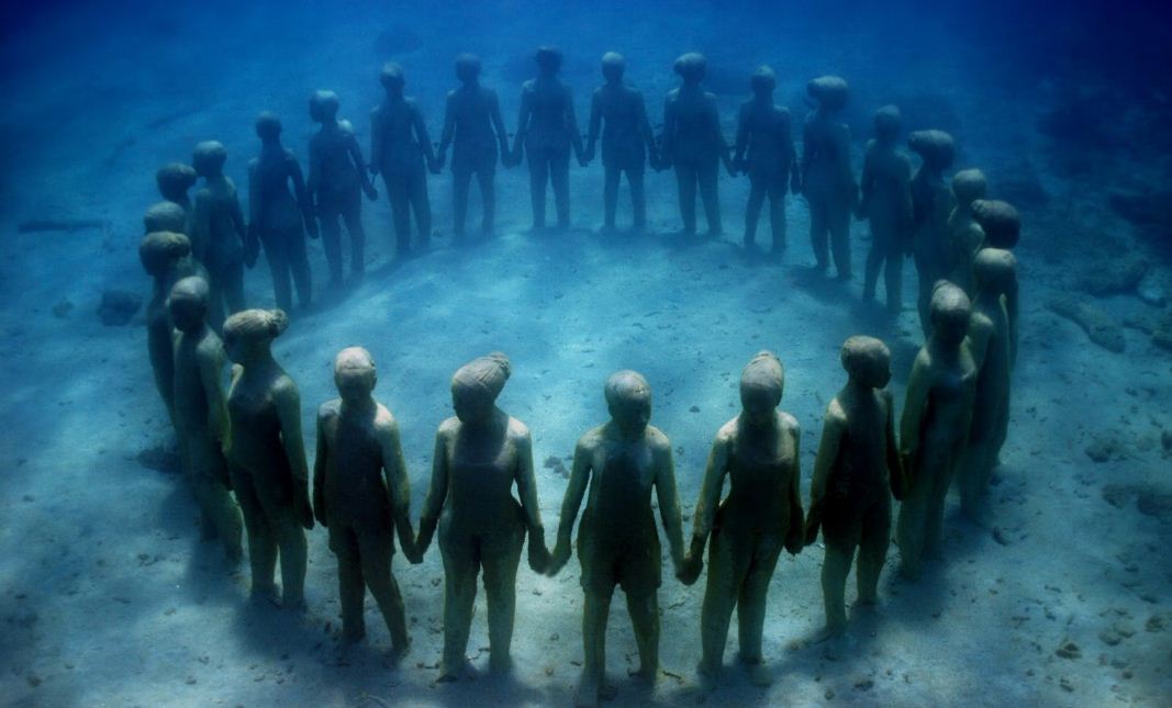 Подводные статуи стоят в кругу, взявшись за руки.